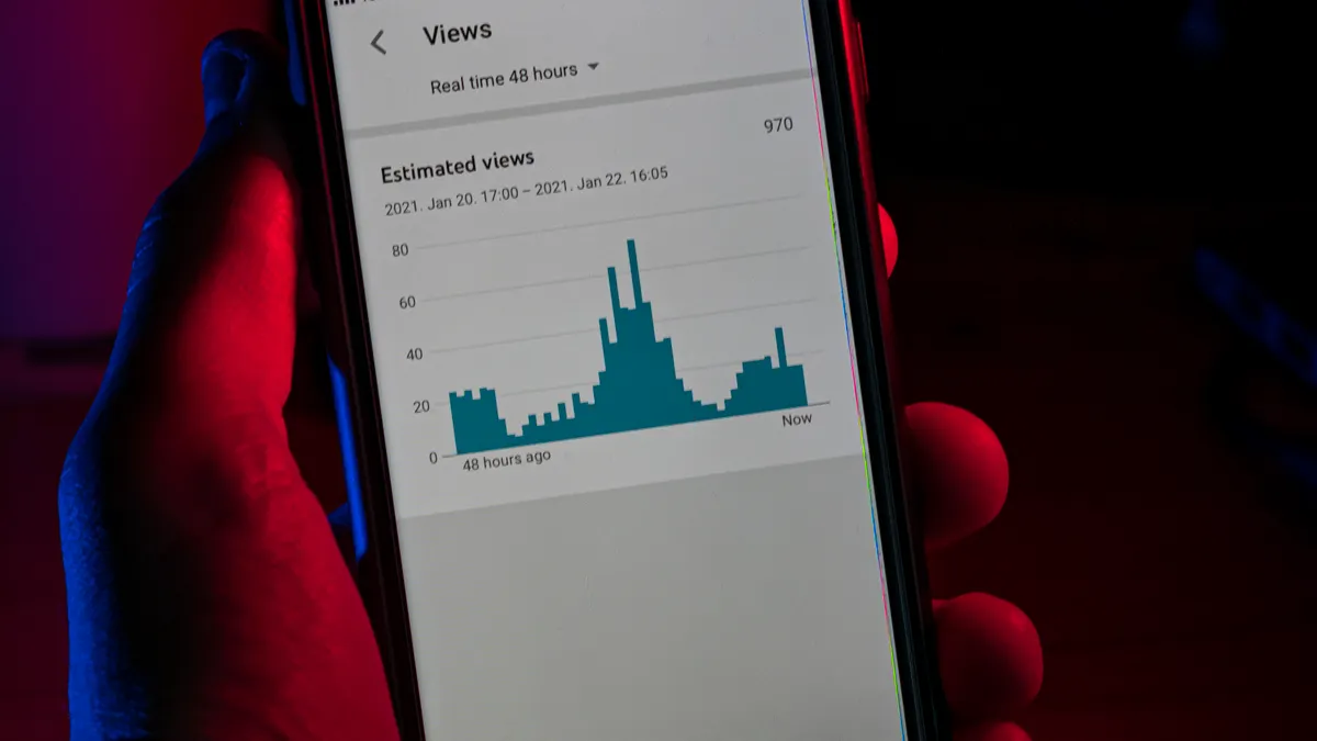 Pessoa segurando smartphone com gráfico de analytics na tela